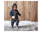 Un enfant dans une combinaison de neige bleue avec une étoile joue dans la neige.