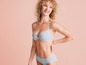 Une femme portant un soutien-gorge et une culotte gris.