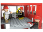 Trois pompiers dans une caserne de pompiers faite avec des briques LEGO.