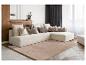 Canapé d'angle beige avec coussins dans un salon avec panneaux muraux en bois et blancs.
