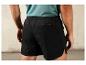 Un homme porte un short de sport noir avec une poche arrière.