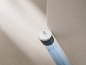 Robot aspirateur blanc lavant le sol le long d'un mur