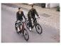 Deux personnes font du vélo sur une rue de la ville sur deux vélos électriques.