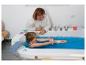Femme et enfant jouant avec une poupée dans une baignoire remplie d'eau bleue.