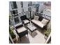 Ensemble de mobilier de balcon en osier noir avec coussins beiges et table en verre.