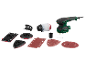 Une ponceuse électrique avec accessoires, y compris des patins de ponçage et du papier abrasif.