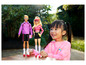 Poupées Barbie et Ken avec des rollers, tenues par un enfant.