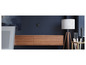 Un amplificateur Wi-Fi Mi fixé à un mur bleu foncé au-dessus d'un meuble TV en bois.