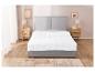 Couette blanche sur lit gris, style minimaliste.