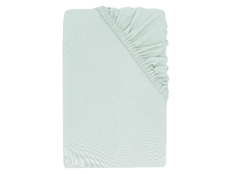 Drap-housse vert clair, plié à plat.