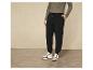 Pantalon de jogging noir avec des baskets blanches.