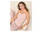 Femme en pyjama rose à motifs assise sur une chaise.