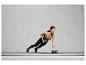 Une femme fait un exercice avec deux haltères de 4 kg sur un tapis de yoga.