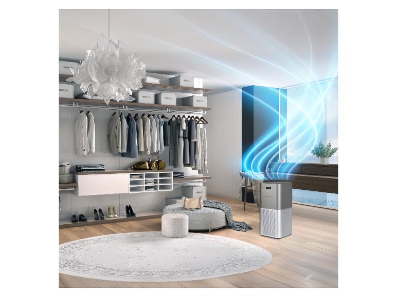 Purificateur d'air argenté dans un dressing moderne avec vêtements et accessoires.