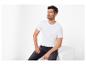 Homme en T-shirt blanc et jean foncé assis sur un cube blanc