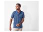 Un homme porte un polo bleu marine et un pantalon beige.