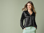 Une femme porte une chemise en satin noir à manches longues.