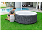 Un homme installe un spa gonflable Lay-Z-Spa dans le jardin.