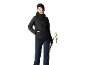 Femme en veste de ski noire, pantalon bleu foncé et lunettes de ski, tenant des bâtons.
