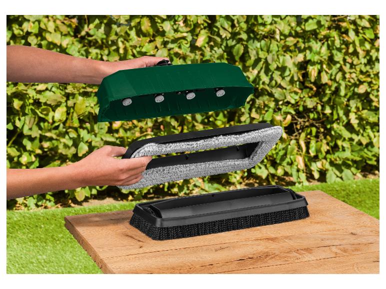 Personne assemblant un outil de nettoyage vert et noir avec une brosse et un tampon microfibre.