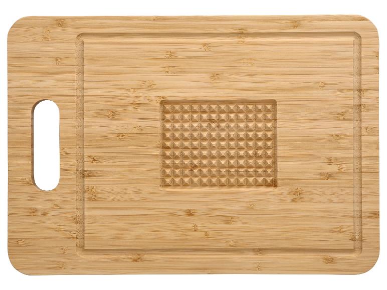 Planche à découper en bambou avec rainure à jus et surface gaufrée.