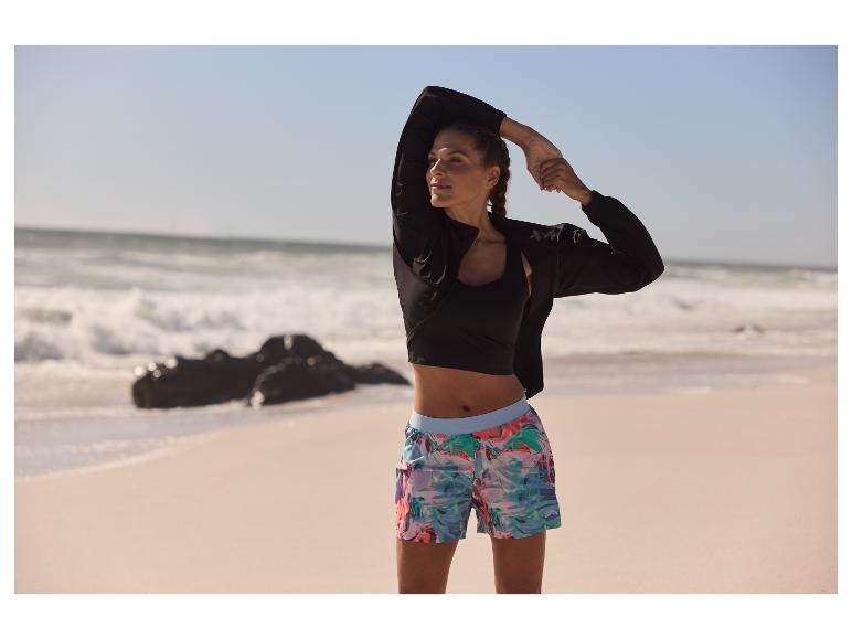 Vêtements de sport : veste, haut et shorts à fleurs sur une plage.