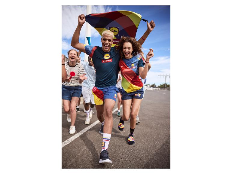 Un groupe de personnes courant et acclamant, vêtues de vêtements de sport colorés et à motifs.