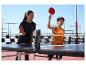 Femme et enfant jouant au tennis de table avec des raquettes rouges, table et filet Crivit.