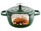 Marmite en fonte verte avec un poulet rôti et des légumes à l'intérieur, vue en coupe.
