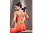 Une femme en tenue de sport utilise un pistolet de massage Volano sur son dos.