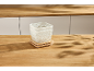 Deux paniers en maille blanche avec couvercles en bois sur une table en bois.