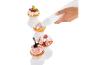 Une main décorant des cupcakes avec de la crème fouettée