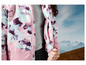 Une veste rose avec un imprimé abstrait, sur fond de montagnes.