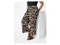 Pantalon grande taille avec imprimé abstrait noir et beige et sandales noires.