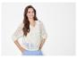 Modèle féminin portant un pull blanc ajouré et un pantalon bleu clair.
