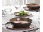 Table dressée avec des bols et assiettes en céramique marron foncé, des verres d'eau et des couverts.