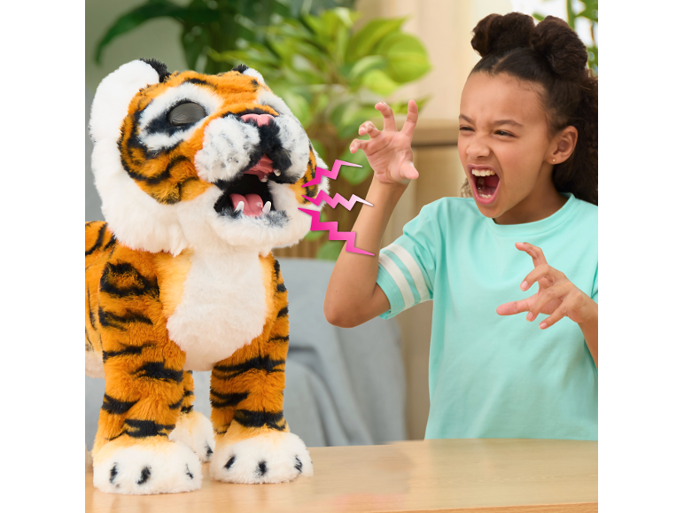 Une fille rugit aux côtés d'un tigre en peluche interactif.