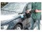 Homme lavant une voiture avec un nettoyeur haute pression et une buse à mousse.