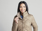 Une femme porte une veste matelassée beige.