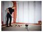 Femme peignant un mur avec la lampe de travail LIVARNO® «The Painter».