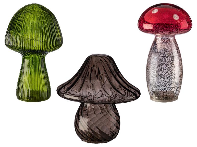 Trois champignons décoratifs en verre vert, marron et rouge avec des accents argentés.