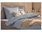 Parure de lit à carreaux bleu clair avec coussins décoratifs et jeté de lit beige sur un lit.