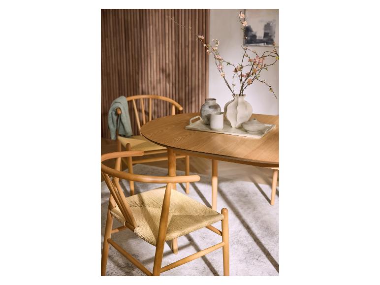 Table à manger en bois avec chaises et décoration florale sur un plateau.