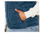 Un homme porte une veste matelassée bleu foncé.