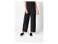 Une femme portant un pantalon noir ample et des baskets noires sans lacets.