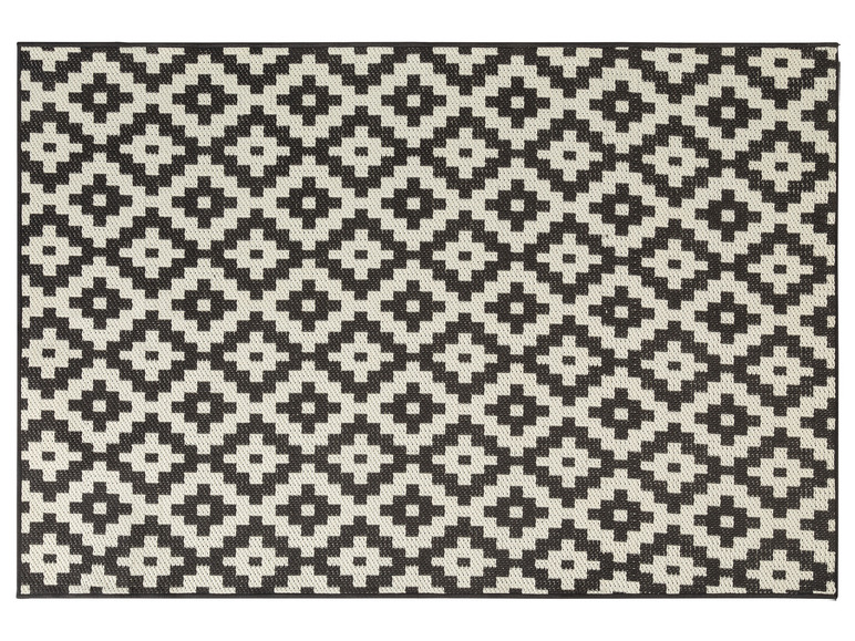 Un tapis tissé noir et blanc avec un motif géométrique.