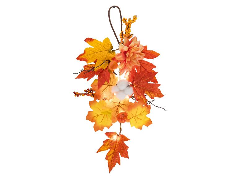 Guirlande d'automne avec feuilles, baies, fleurs, détails en coton et éclairage.