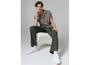 Homme en chemise à fleurs, pantalon vert et baskets Vans blanches