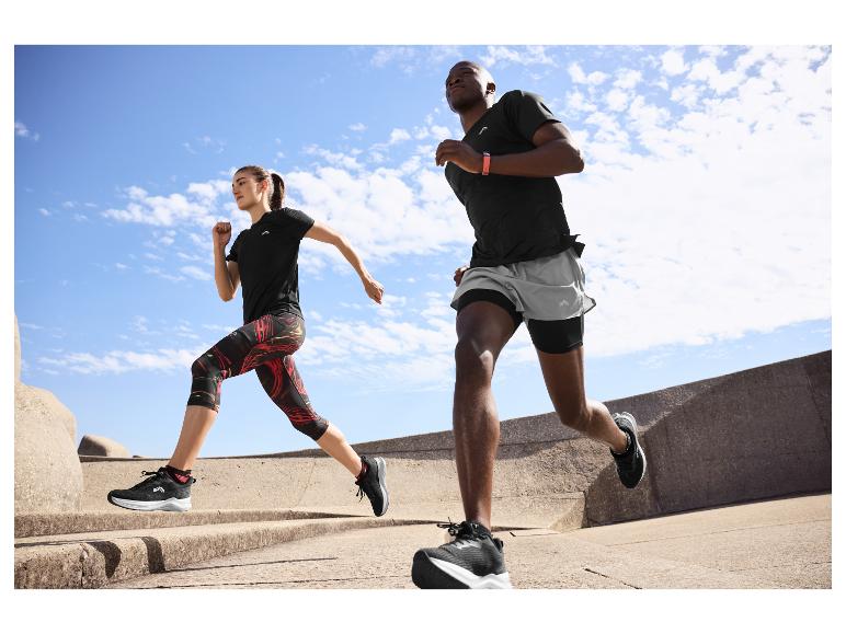 Deux personnes courant en extérieur en tenue de sport noire et grise, avec des traqueurs d'activité.