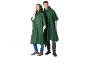 Deux personnes portant des ponchos de pluie vert foncé à capuche, des jeans et des bottes.